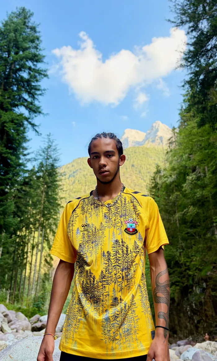 Yellow Southampton shirt with a forest print, mountains behind